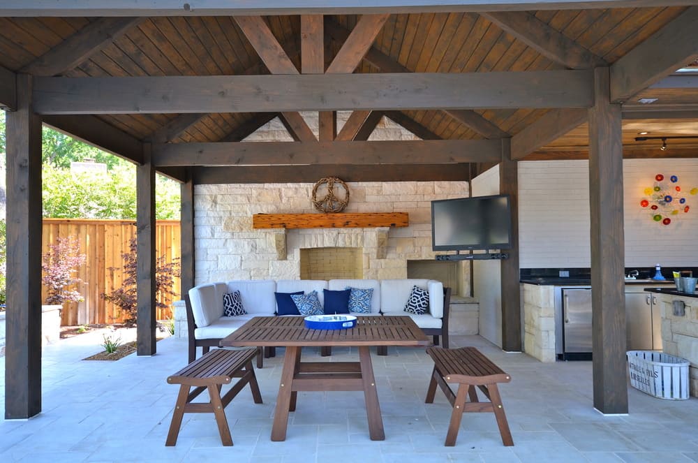 Outdoor Seating Area with Wooden Table and Bence and Fireplace