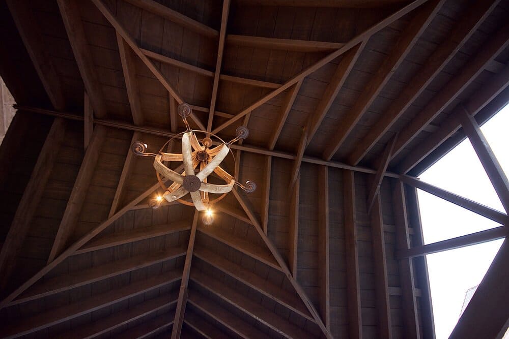 Beautiful Chandelier Hanging Off of Wooded Ceiling